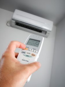 closeup-view-of-hand-turning-on-ductless-air-handler-remotely