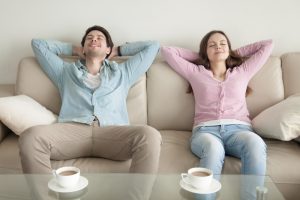 young-couple-sitting-in-home-smiling