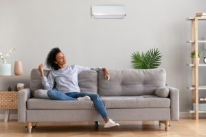 woman-in-living-room-enjoying-cool-breeze-from-ductless-air-conditioner