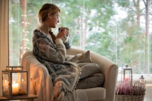 woman-sitting-on-comfy-chair-sipping-out-of-mug